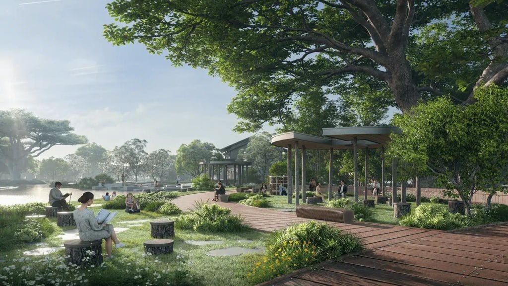 Công viên ven sông Hồng tại Alluvia City: Không gian thư giãn lý tưởng 3 Hình ảnh công viên ven hồ tại Alluvia City, với lối đi gỗ uốn lượn, ghế ngồi làm từ thân cây, và khu vực nghỉ ngơi dưới mái che. Xung quanh là cây xanh, hoa cỏ, và hồ nước phản chiếu ánh sáng, tạo nên không gian thư giãn lý tưởng cho cư dân.