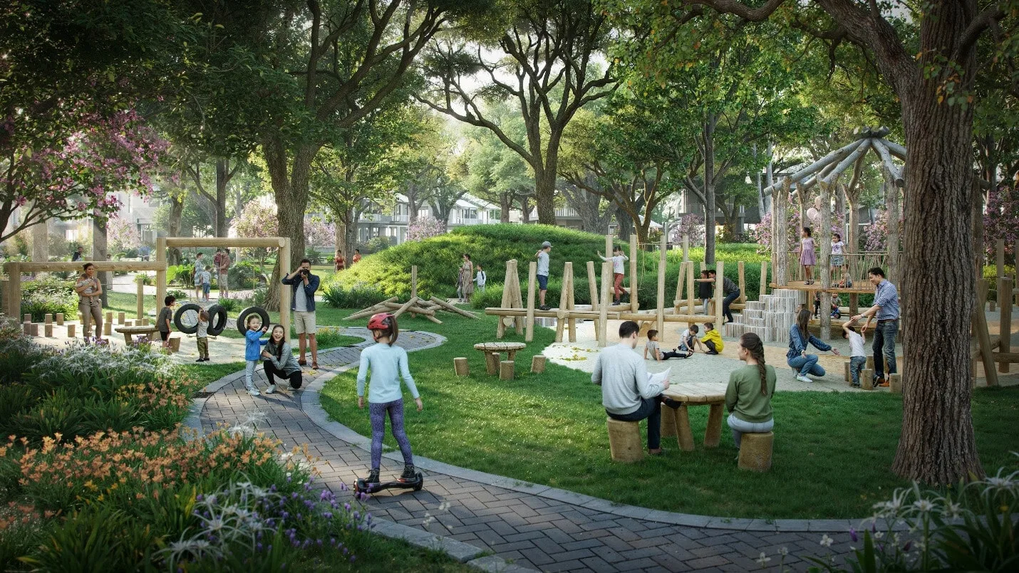 Hình ảnh một công viên tại Alluvia City với nhiều trẻ em và người lớn đang vui chơi, thư giãn. Công viên có các khu vực chơi bằng gỗ, bàn ghế gỗ, lối đi lát gạch, và nhiều cây xanh, hoa cỏ xung quanh, tạo nên không gian trong lành và gần gũi với thiên nhiên.