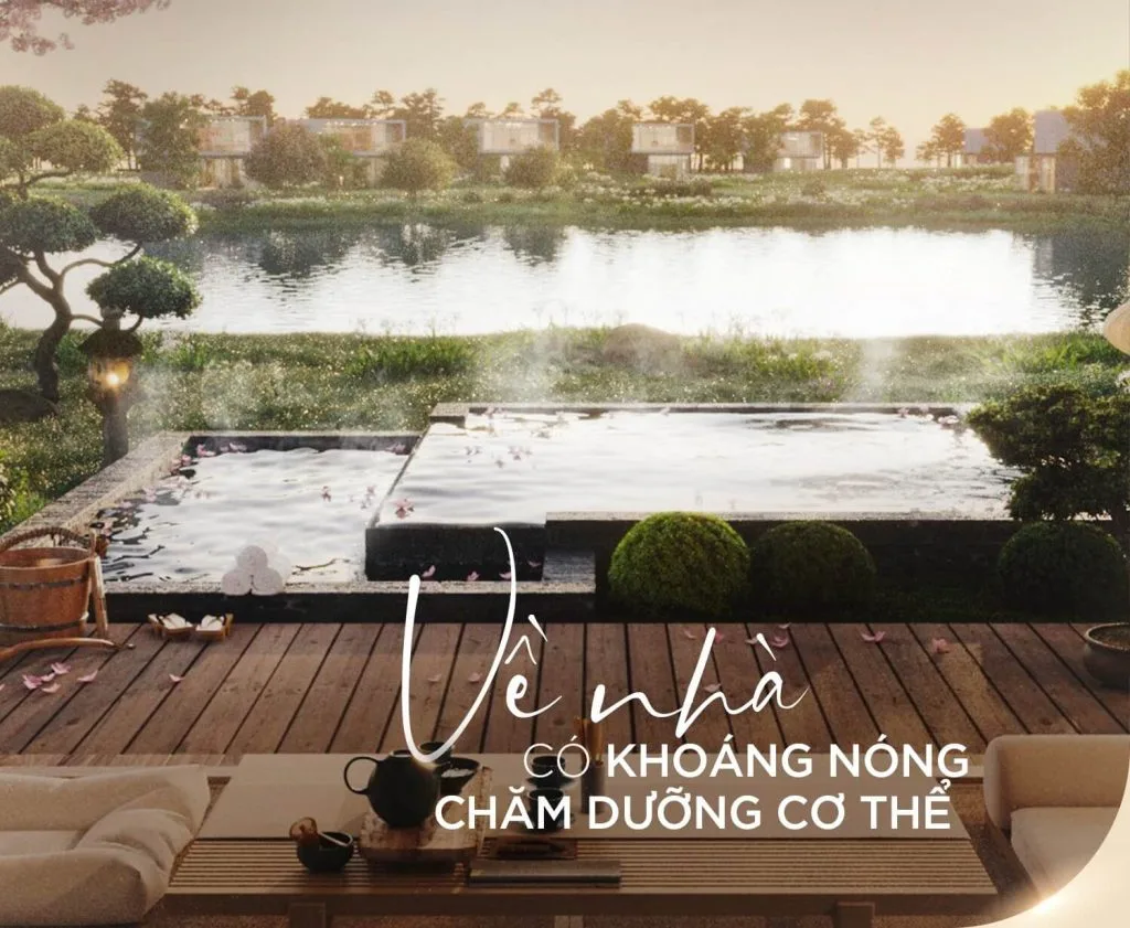 Hình ảnh một khu vực thư giãn ngoài trời tại Alluvia City Văn Giang với bể khoáng nóng, bao quanh bởi cây xanh và hồ nước yên bình. Sàn gỗ được trang trí với bộ bàn trà và ghế sofa, tạo không gian ấm cúng. Chữ "VỀ NHÀ CÓ KHOÁNG NÓNG CHĂM DƯỠNG CƠ THỂ" được in nổi bật, nhấn mạnh giá trị của khoáng nóng tự nhiên tại dự án.