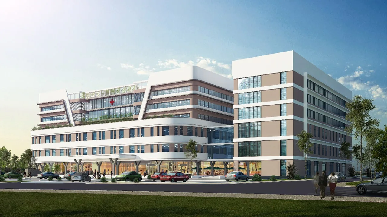 Phối cảnh bệnh viện đa khoa nằm tại trung tâm dự án, được quy hoạch với quy mô lớn, cung cấp dịch vụ chăm sóc sức khỏe chất lượng cao Hình ảnh phối cảnh bệnh viện đa khoa hiện đại tại Alluvia City, với tòa nhà cao tầng thiết kế khối vuông vức, mặt kính rộng, khuôn viên xanh và bãi đỗ xe phía trước.